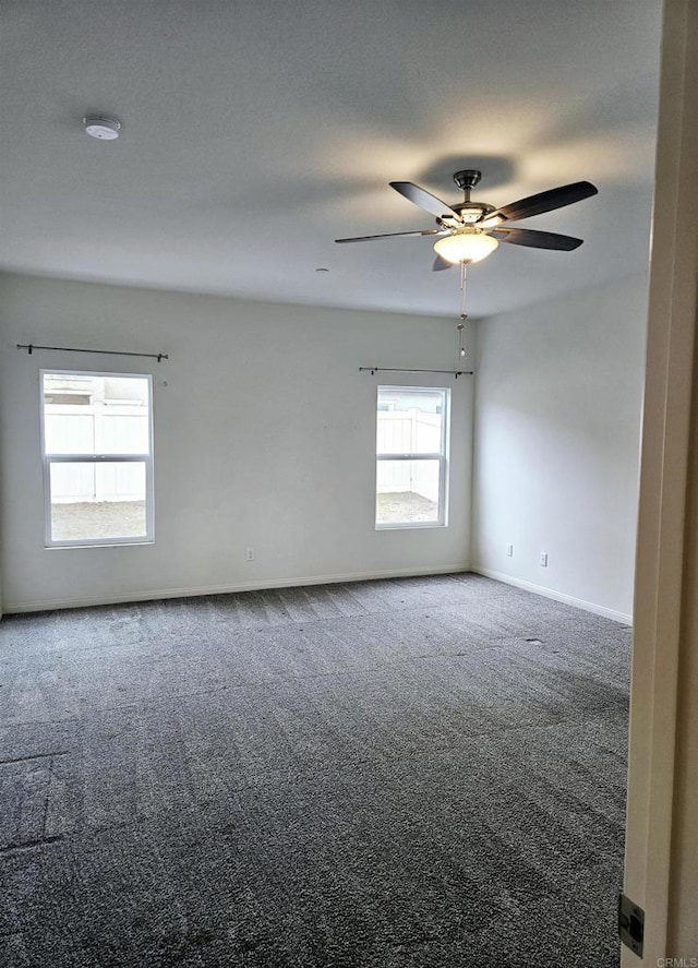 spare room featuring baseboards, carpet floors, and a ceiling fan