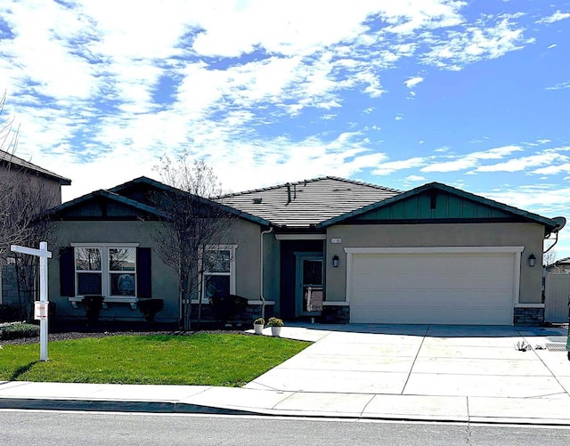 single story home featuring a tile roof, a front yard, stucco siding, a garage, and driveway