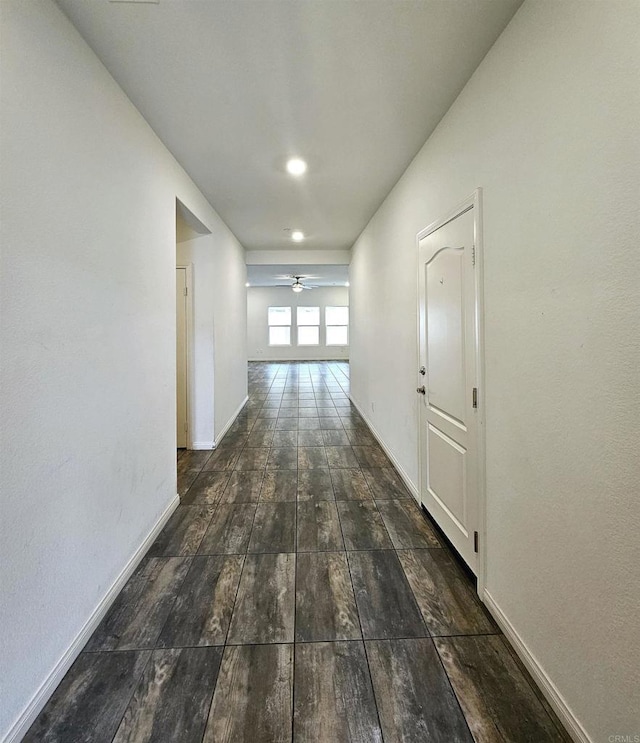 hallway featuring wood finished floors and baseboards