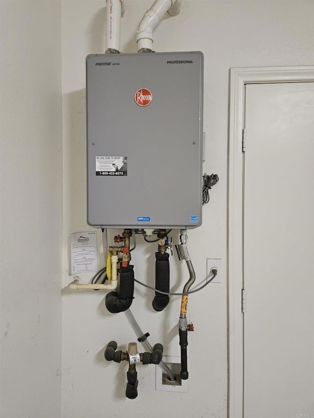 utility room featuring tankless water heater