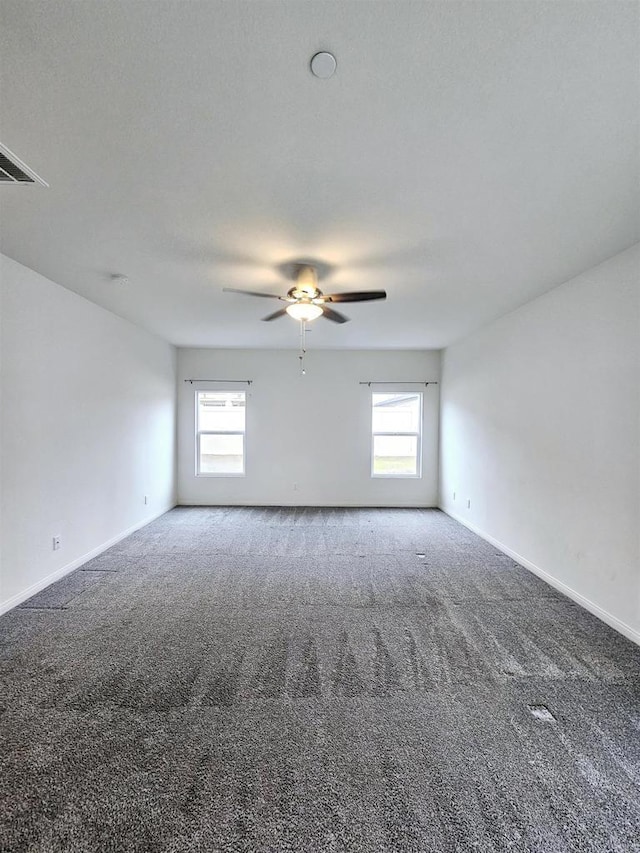 carpeted empty room featuring a ceiling fan, a healthy amount of sunlight, and baseboards