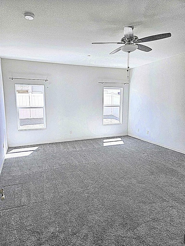 spare room featuring a ceiling fan, baseboards, and carpet