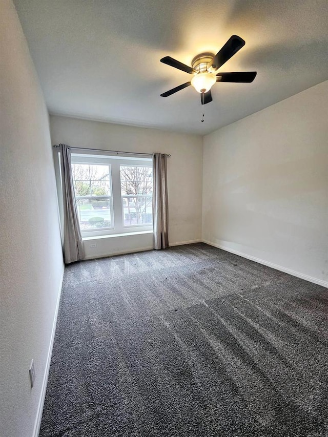 carpeted empty room with a ceiling fan and baseboards