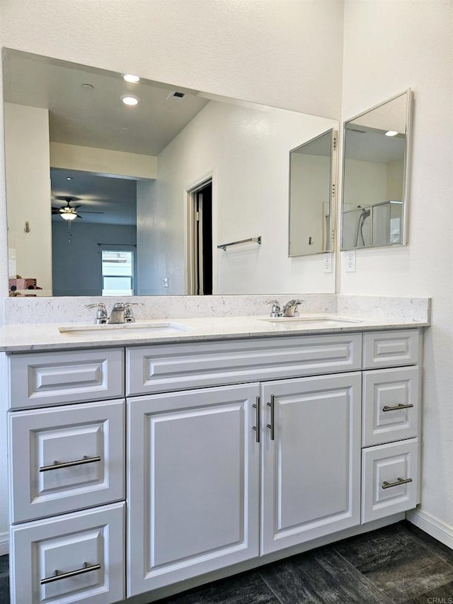 full bathroom featuring double vanity, a ceiling fan, and a sink