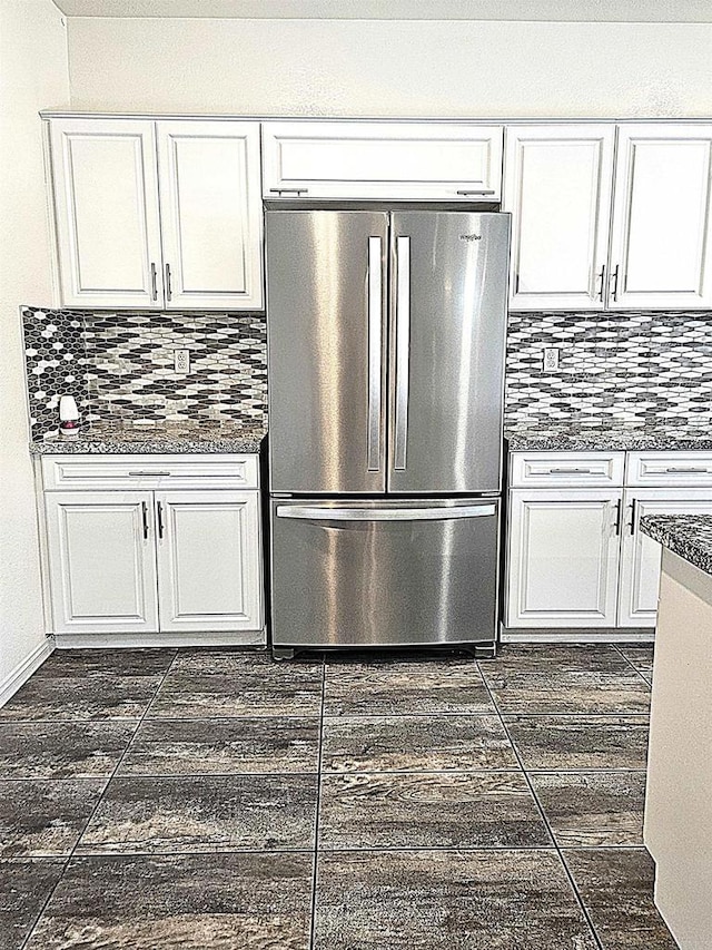 kitchen with freestanding refrigerator, white cabinets, and decorative backsplash