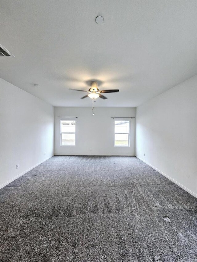 spare room with carpet flooring, a ceiling fan, baseboards, and plenty of natural light