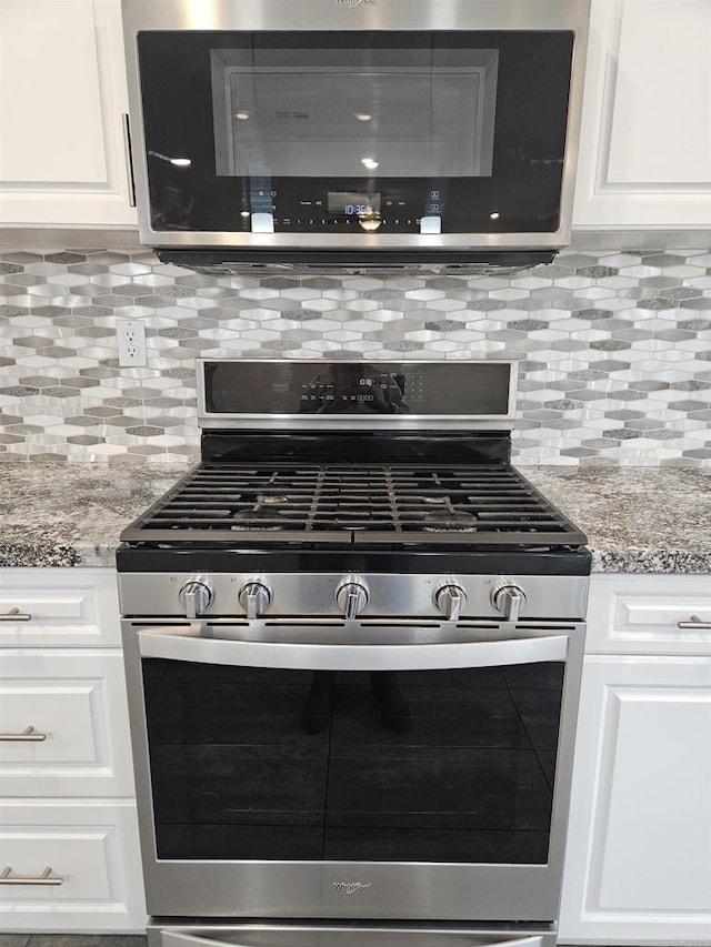 kitchen with white cabinets, light stone countertops, appliances with stainless steel finishes, and decorative backsplash