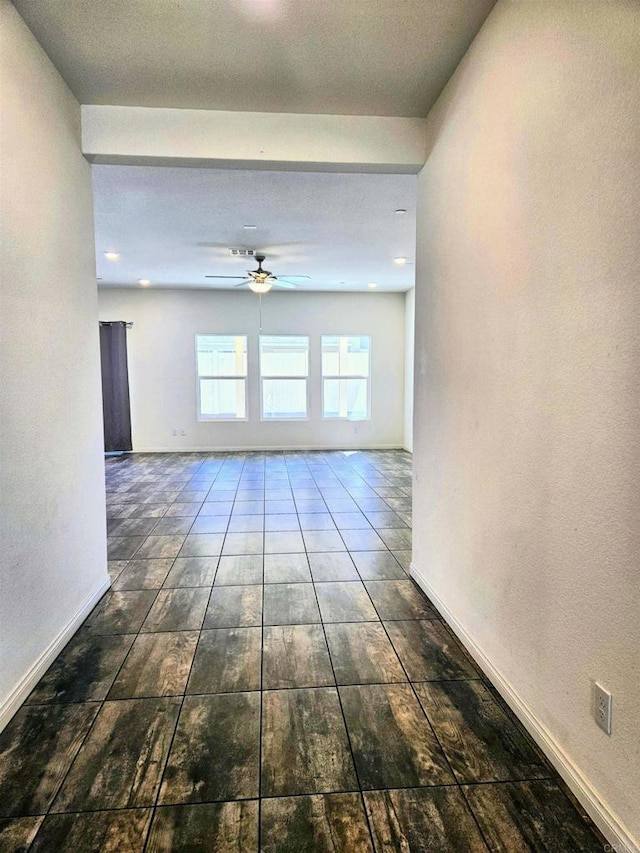 empty room with baseboards and a ceiling fan