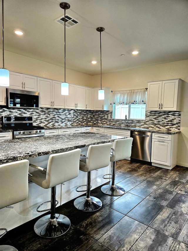 kitchen with stainless steel appliances, visible vents, decorative backsplash, and white cabinetry