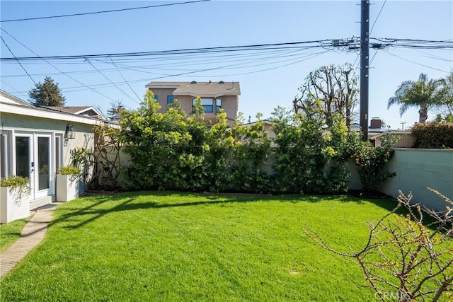 view of yard featuring french doors and a fenced backyard