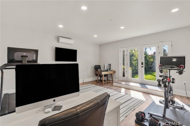 workout room featuring baseboards, a wall mounted AC, recessed lighting, french doors, and light wood-type flooring