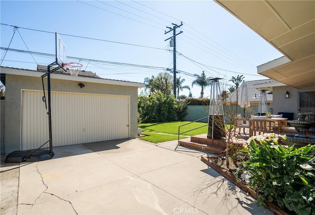 view of patio / terrace featuring a detached garage, fence, and an outdoor structure