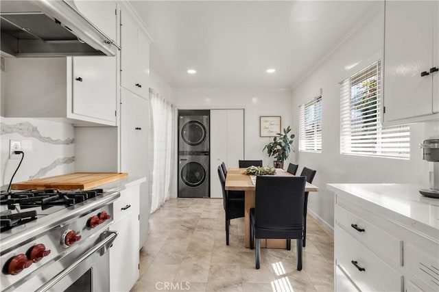 dining space with stacked washer / dryer, recessed lighting, baseboards, and ornamental molding