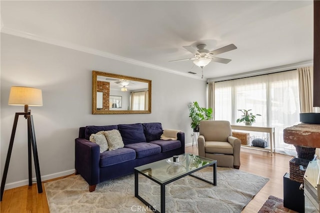 living room featuring visible vents, ornamental molding, wood finished floors, baseboards, and ceiling fan