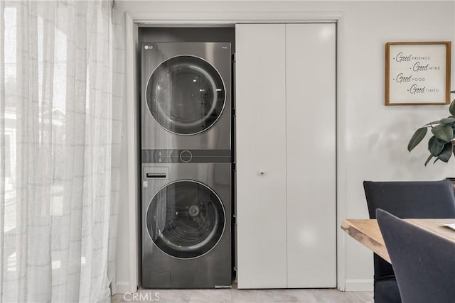 clothes washing area with laundry area and stacked washer / dryer