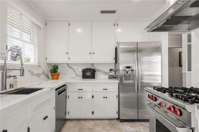 kitchen with premium range hood, visible vents, a sink, stainless steel appliances, and white cabinets