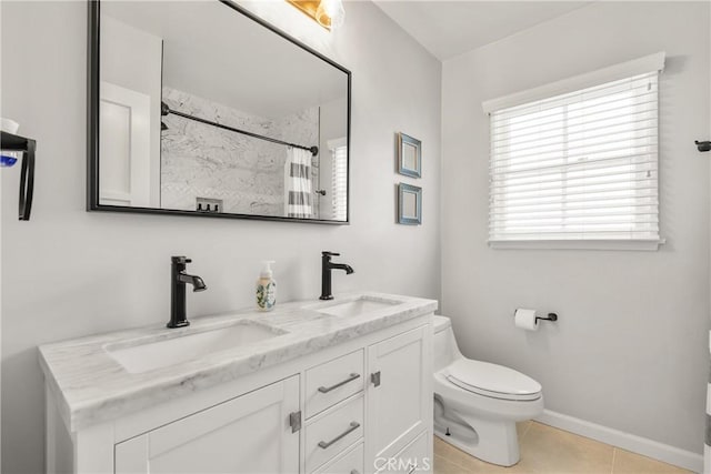 bathroom with tile patterned floors, double vanity, toilet, and a sink