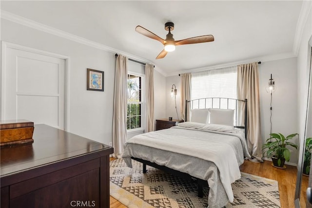 bedroom with ceiling fan, light wood-type flooring, and ornamental molding