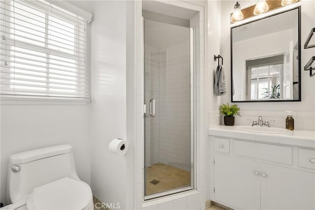 bathroom with vanity, toilet, and a stall shower