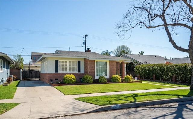 view of front of property with a gate, concrete driveway, a front yard, crawl space, and brick siding