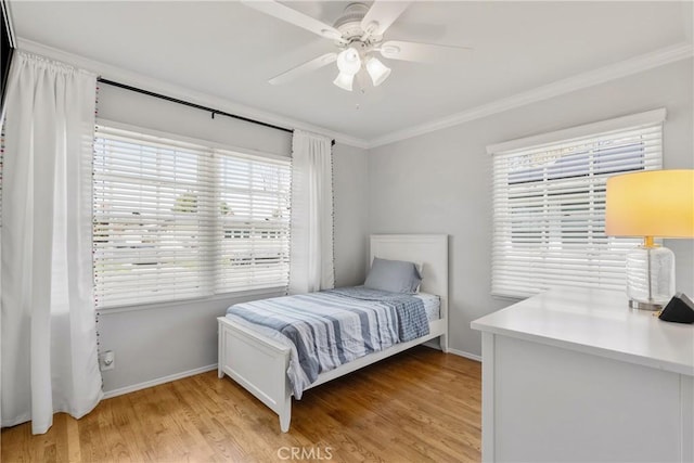 bedroom with light wood finished floors, a ceiling fan, crown molding, and baseboards