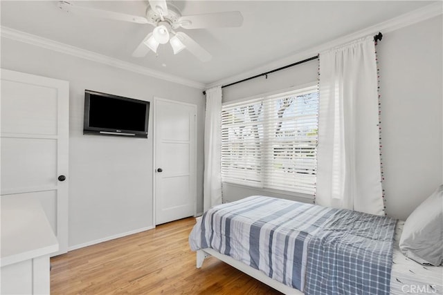 bedroom with light wood-style floors, ornamental molding, and a ceiling fan