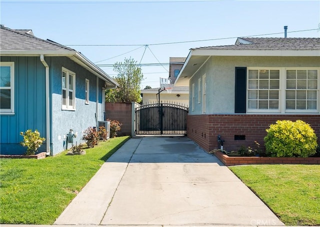 view of side of property with brick siding, board and batten siding, a yard, crawl space, and a gate