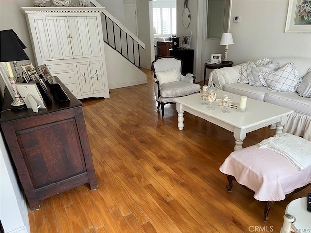 living area featuring light wood-style flooring and stairway