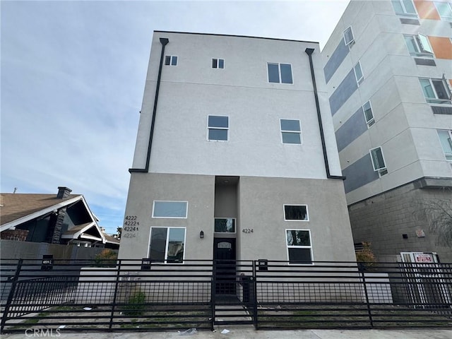 view of front of property with a fenced front yard and stucco siding