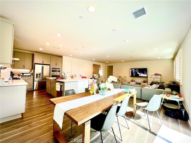 dining space with visible vents, wood finished floors, and recessed lighting