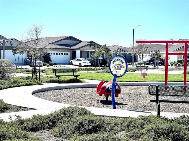 view of home's community with concrete driveway, a yard, and an attached garage