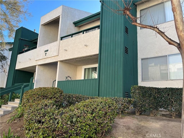 view of property exterior with a balcony and stucco siding