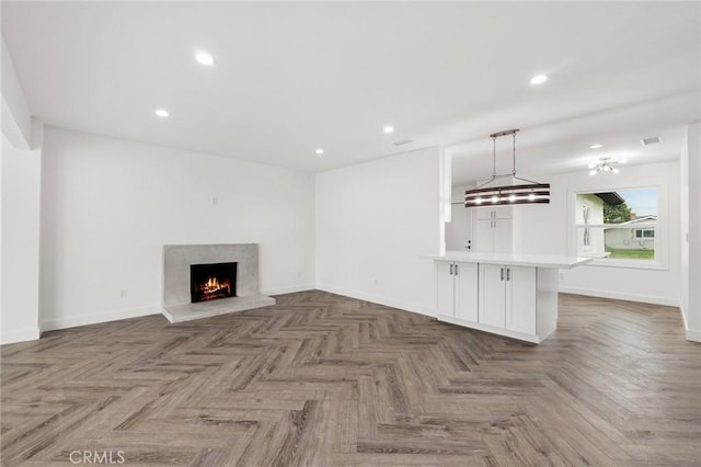 unfurnished living room with recessed lighting, visible vents, baseboards, and a high end fireplace