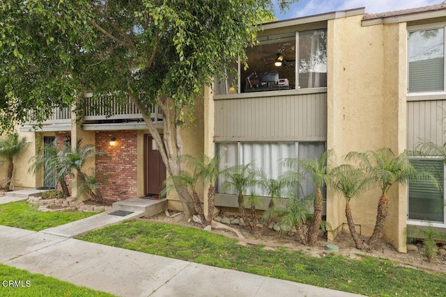 view of front facade with a balcony and stucco siding