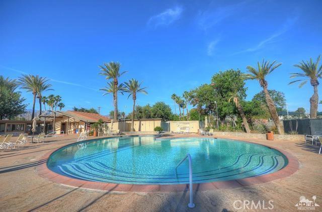 community pool with a patio area and fence