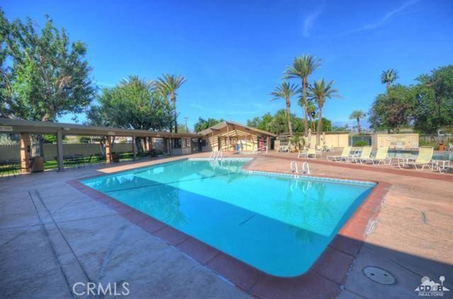 community pool featuring a patio area and fence