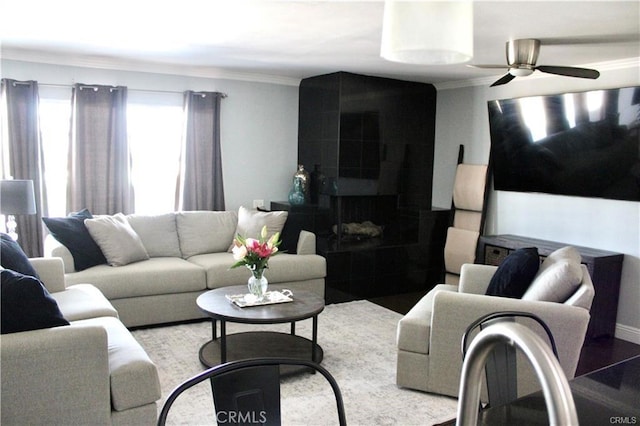 living room featuring wood finished floors, crown molding, and ceiling fan