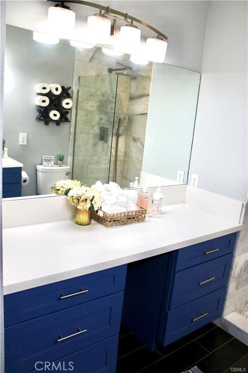 bathroom with a stall shower, vanity, and toilet