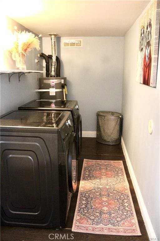 laundry room with laundry area, visible vents, baseboards, water heater, and separate washer and dryer