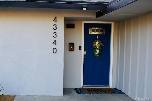 doorway to property featuring stucco siding