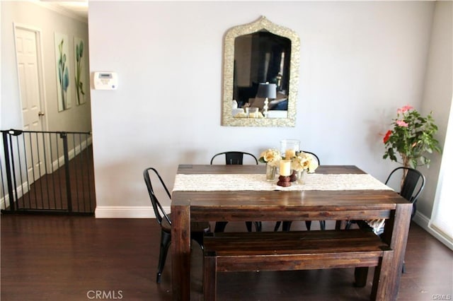 dining area featuring dark wood-style flooring and baseboards