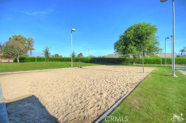 view of home's community featuring a lawn and volleyball court