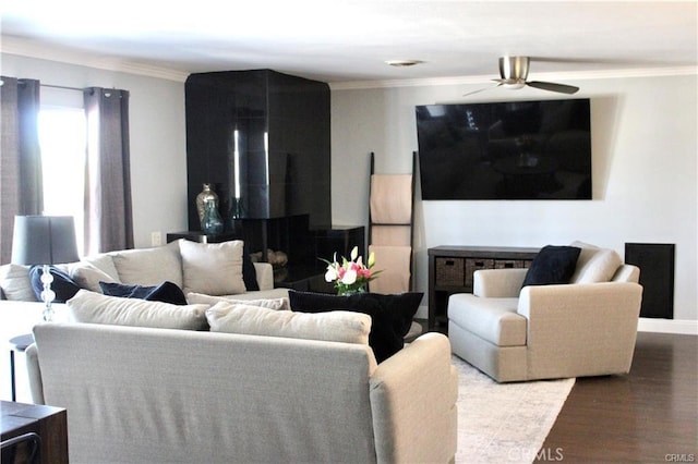 living room featuring baseboards, crown molding, a ceiling fan, and wood finished floors