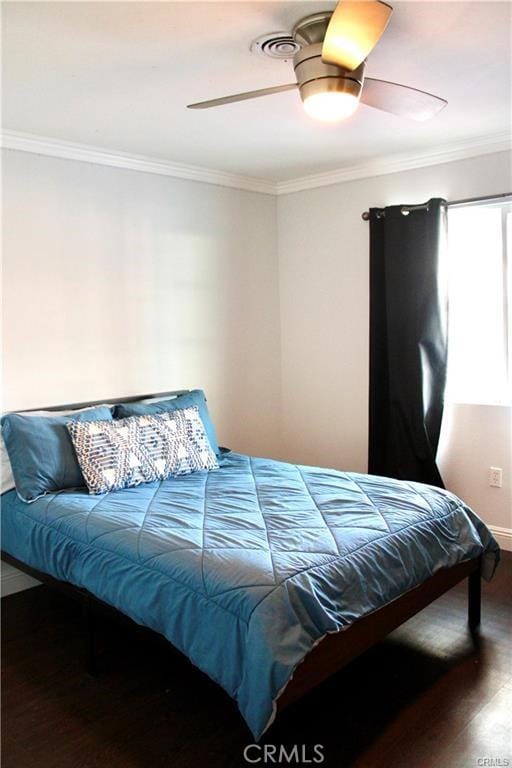 bedroom with wood finished floors, a ceiling fan, and crown molding