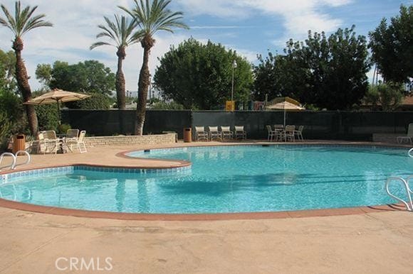 community pool featuring a patio area and fence