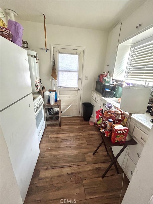 kitchen with white appliances, secured water heater, and dark wood finished floors