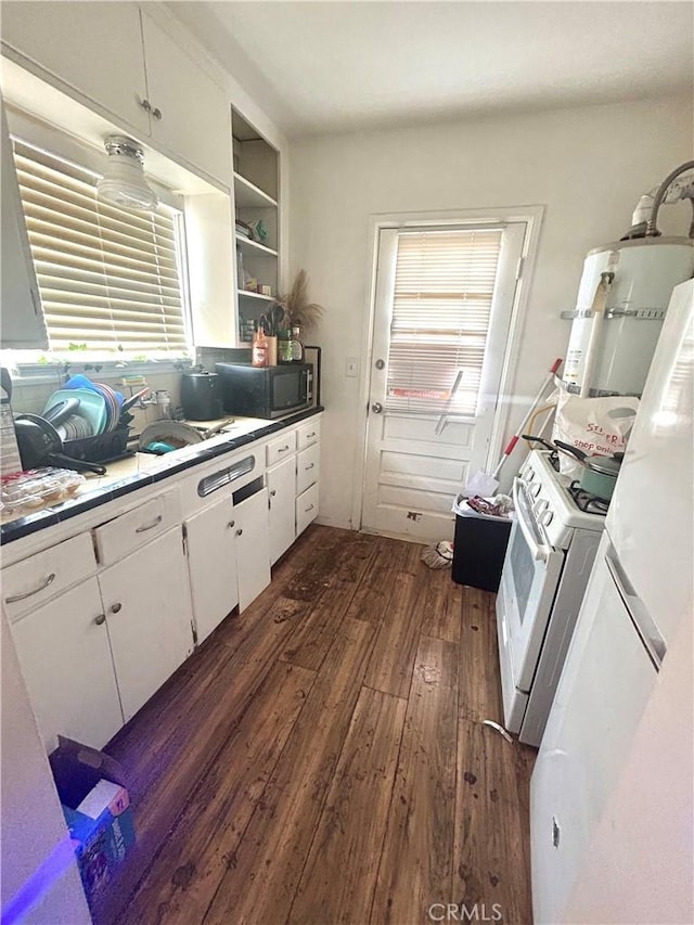 kitchen with white cabinets, dark wood-style flooring, black microwave, open shelves, and gas water heater