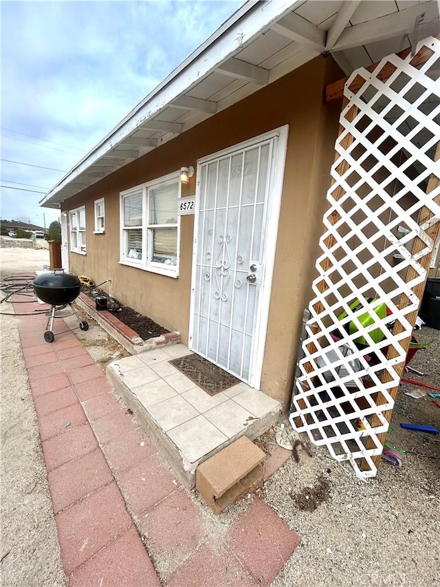 property entrance with stucco siding