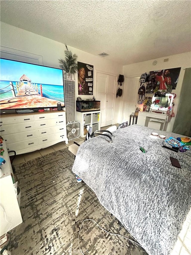 bedroom featuring tile patterned flooring and a textured ceiling