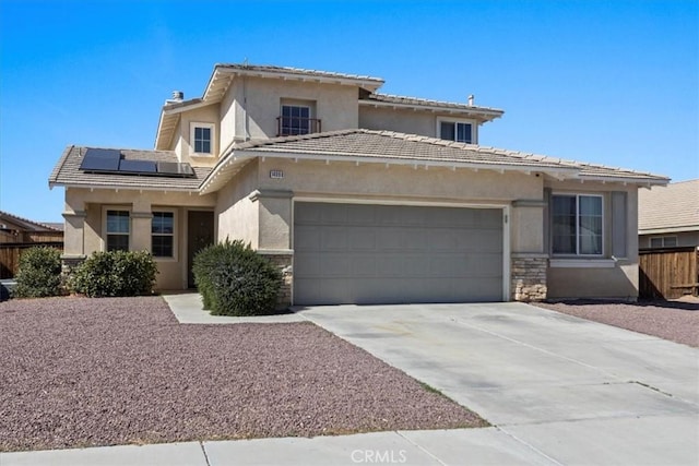 prairie-style home with a garage, solar panels, stone siding, driveway, and stucco siding